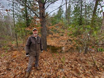 Bill Bobier stands in the woods on his family's property. 