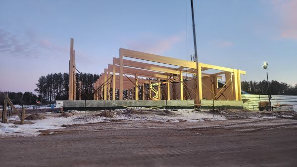 Wooden uprights are placed in the ground for a building being constructed 