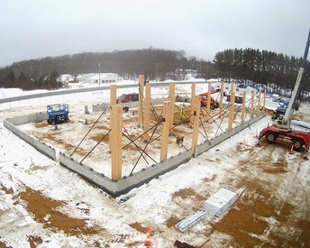 Aerial image of construction site in winter with crane and wooden building parts 