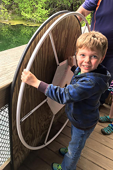 young boy turns wheel on Big Spring raft