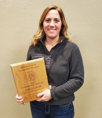 Jenilee Dean holds the 2024 Stewardship Award plaque