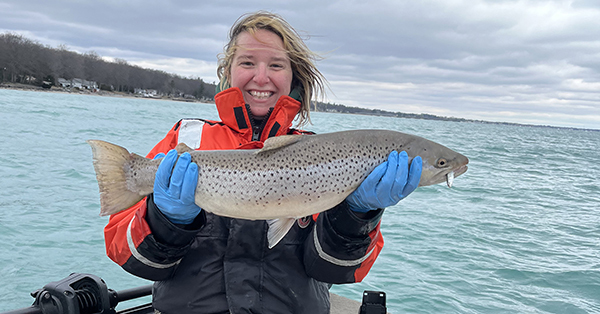 DNr staffer April Simmons in boat holding brown trout