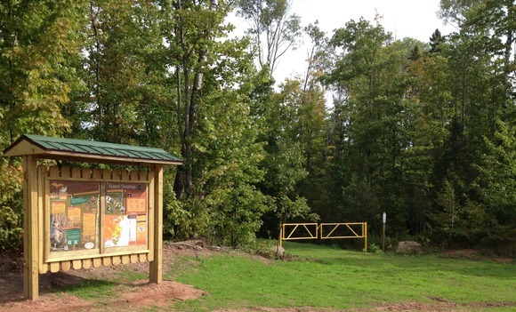 A kiosk for the Grouse Enhanced Management Sites stands next to a yellow gate to access the walk-in area