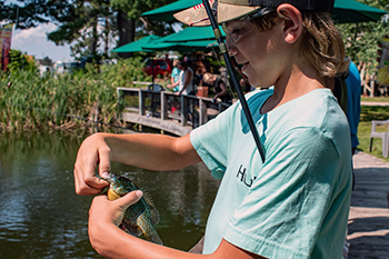 A young angler takes a bluegill he caught off his hook at the DNR's Pocket Park in Delta County.