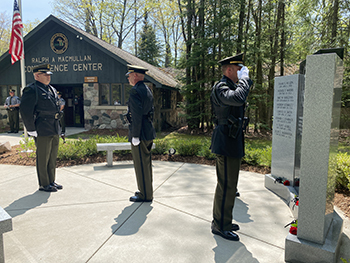 Honor Guard officers salute a memorial