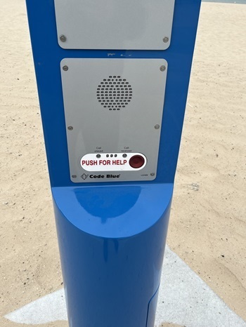 The simple, silver surface of the SwimSmart blue light beach safety tower, showing the "push for help" button and call sent/received status