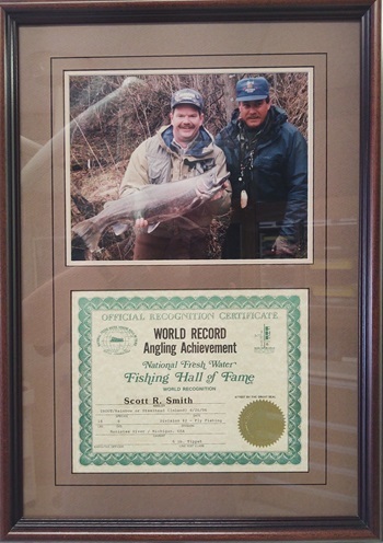 A commemorative frame displays the first world record award for Scott Smith's rainbow trout catch in 1996, with an accompanying photo