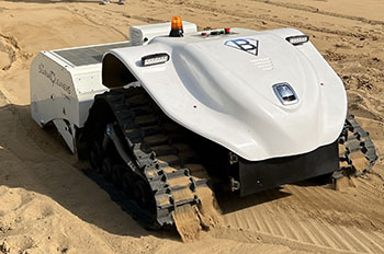 large white machine sitting on sand