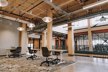 conference tables and chairs spaced out in the tall-ceilinged, exposed ductwork of Michigan State University's STEM building, built with mass timber