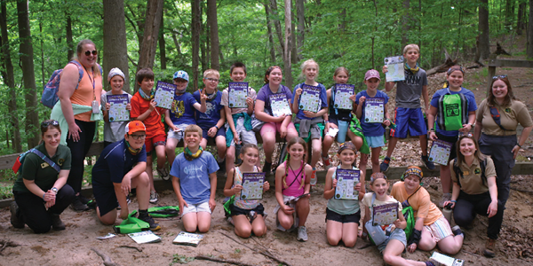 A group of students smile with their teachers after a field trip. 