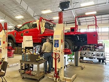 A DNR fire vehicle is shown being worked on in a garage at the service center.
