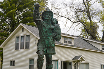 A statue of a firefighter carrying a child is shown from the firemen's memorial.