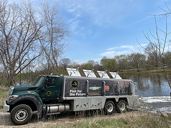 Michigan DNR fish-stocking truck at Grand River in Lyons.