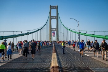 Crowds walk across the Mackinac Bridge.