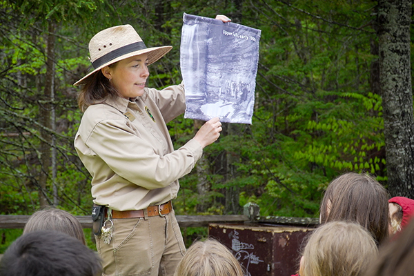 A park interpreter holds up a teaching aid during one of her sessions with participants.