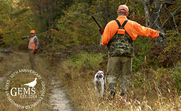 grouse hunters with hunting dog on wooded trail with GEMS logo