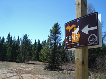 A sign points to the entrance of a Grouse Enhanced Management Site