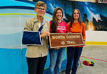 Trail hikers Jane Norton, left, and Jane Langeland, right, stand with Heather Johnson Durocher of the DNR during the annual celebration in St. Ignace.