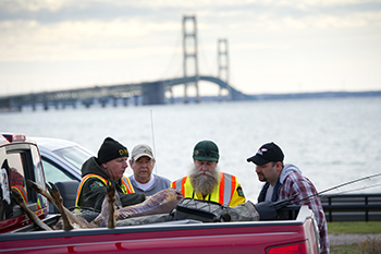 A hunter checks in a deer at a DNR check station in St. Ignace in the shadow of the Mackinac Bridge.