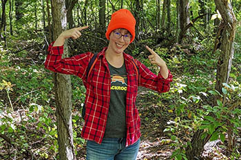 hiker pointing to blaze orange hat on trail