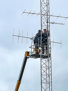 Workers install a Motus antenna in Mackinac County.