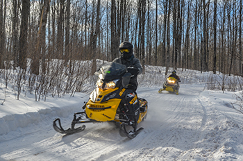 two snowmobiles on snowy trail