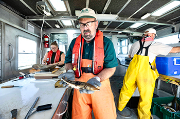 A DNR research biologist holds a young lake sturgeon captured during the 2024 Saginaw Bay fish community survey.  