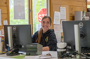 smiling park worker sitting in contact booth 