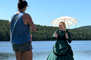 A costumed interpreter at Fort Wilkins speaking with visitors.