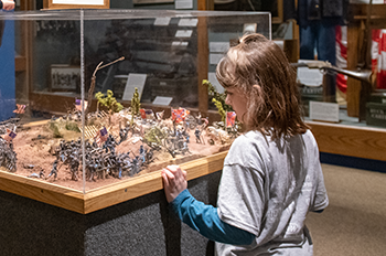 A young child looking at an exhibit at the Michigan History Museum.