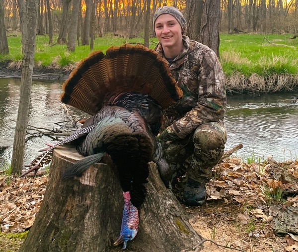 Turkey hunter smiles with harvested turkey