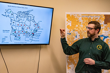 The DNR's Tyler Petroelje discusses moose range with media in Marquette prior to the field operations.