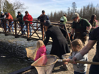 A crowd of people stocking fish in Southeast Michigan.