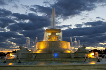 fountain lit up by lights under a dark blue sky