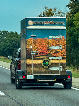 A Hunters Feeding Michigan trailer is shown on the road.