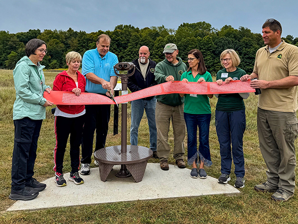 An outdoor ribbon-cutting ceremony for the EnChroma viewers at Maybury State Park is shown.