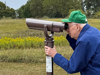 Bill McKnight is shown looking through an EnChroma viewer at Maybury State Park.