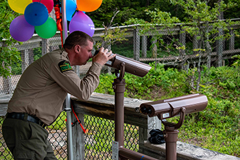 Justin Farley, a park ranger at Porcupine Mountains Wilderness State Park, looks through an EnChroma viewer at a park overlook.