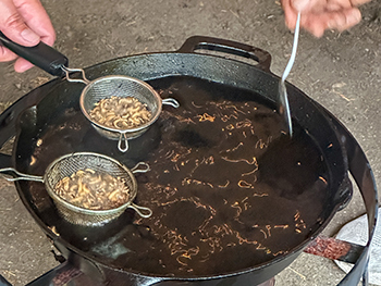 Tribal instructors prepare popped rice from manoomin as a treat for participants at the DNR’s first wild rice camp.