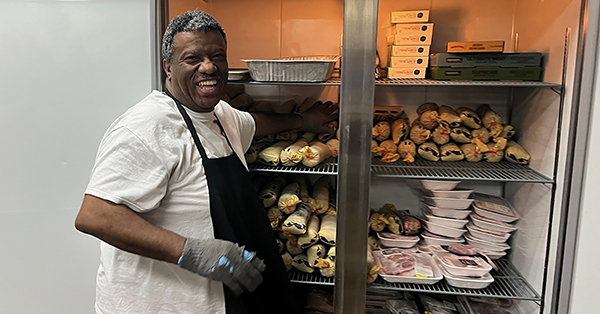 food bank volunteer grans venison bags out of freezer