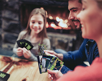 two parents and a child play a card game