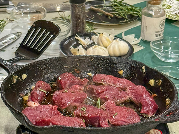 Chunks of venison are shown cooking in a frying pan at a recent deer processing workshop at the OAC in Detroit.