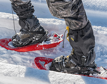 view of leg and top of boot and snowshoe on top of snow