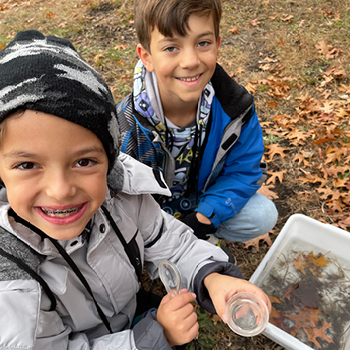 Two boys smiling as they complete a stream sample.