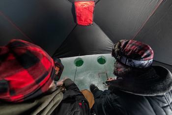 Anglers ice fishing in a shanty.