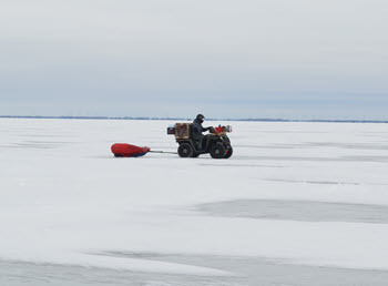 off-road vehicle pulls a sled on the ice