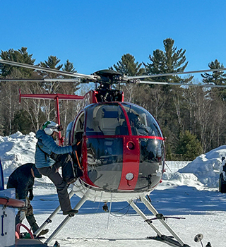 A moose team member boards a helicopter, ready to head to the field.