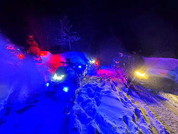 Officers rescue a stranded snowmobiler Monday during a severe storm in Luce County.