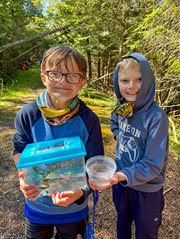 Two Nature Awaits participants display frogs they caught.