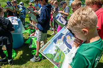 A Nature Awaits participant looks at his workbook on an outing.